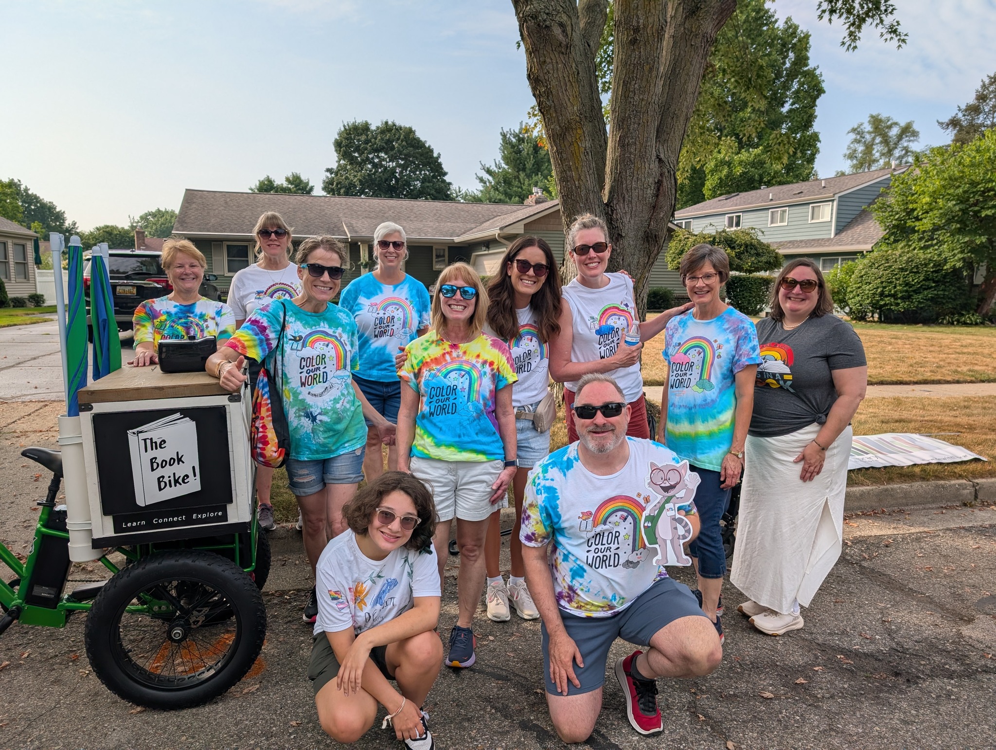 Group of smiling people wearing colorful summer reading shirts and getting ready to walk in the Community Parade