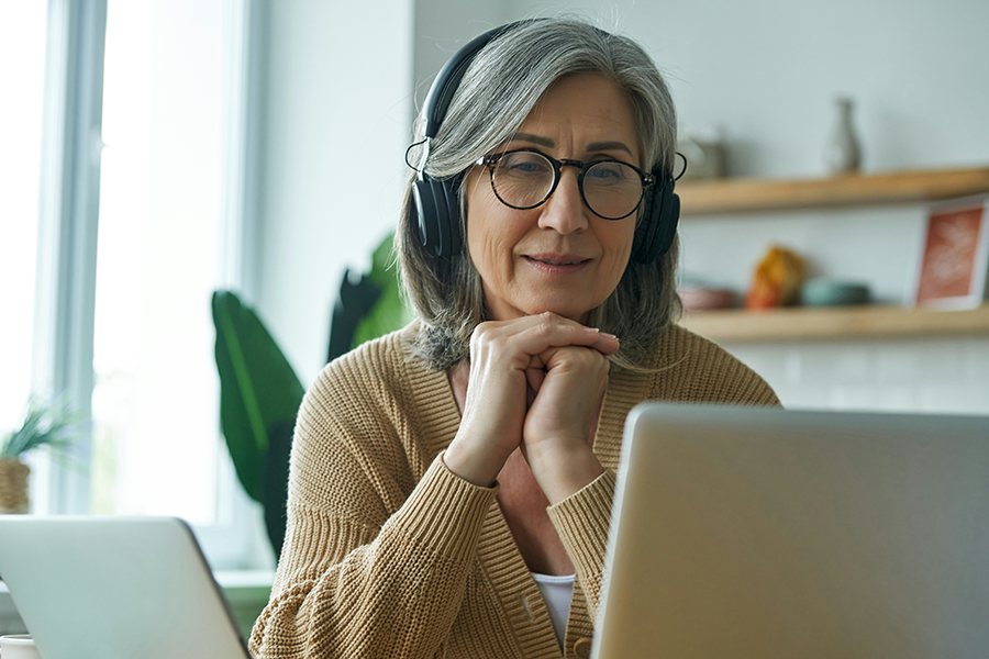 Woman with headphones looking at laptop screen