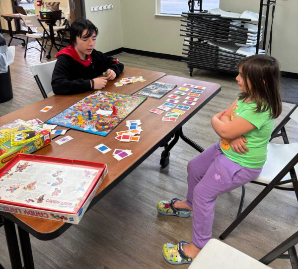 Teen and girl playing Candy Land board game