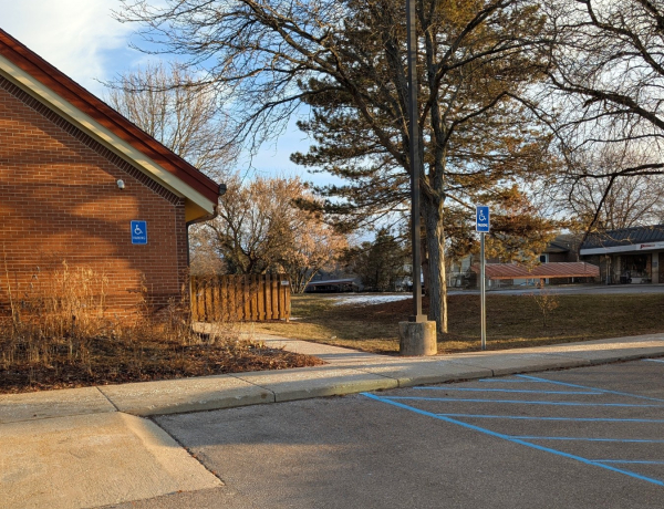 two designated handicap parking spaces showing a ramp to the sidewalk next to the library