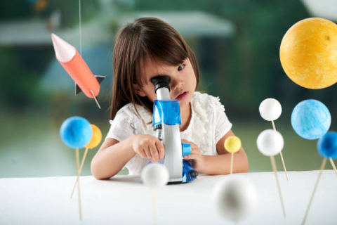 preschool girl with microscope