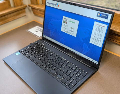 angled image of an open laptop on a table top, the screen of the laptop is blue with a login box in the middle