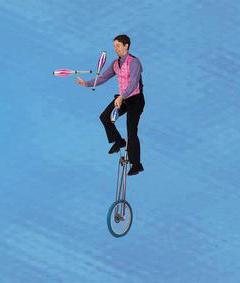 man on a uni-cycle and juggling
