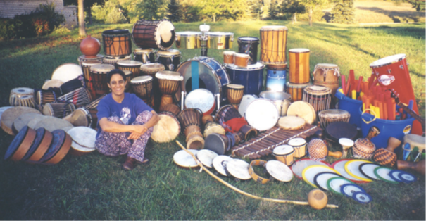 woman seated with drums on grass