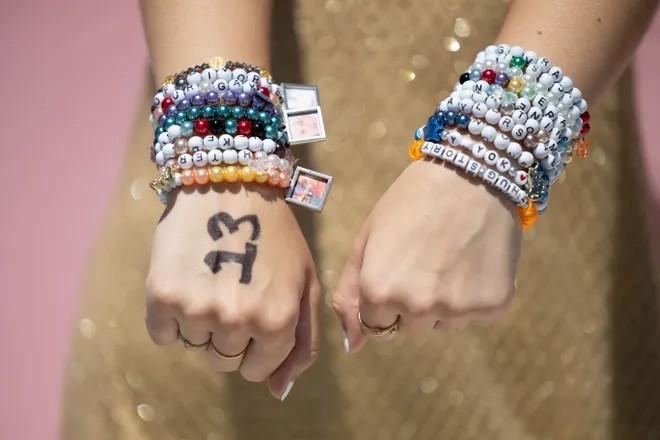 two hands wearing friendship bracelets