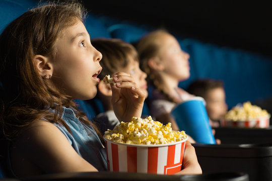 kids at a movie eating popcorn